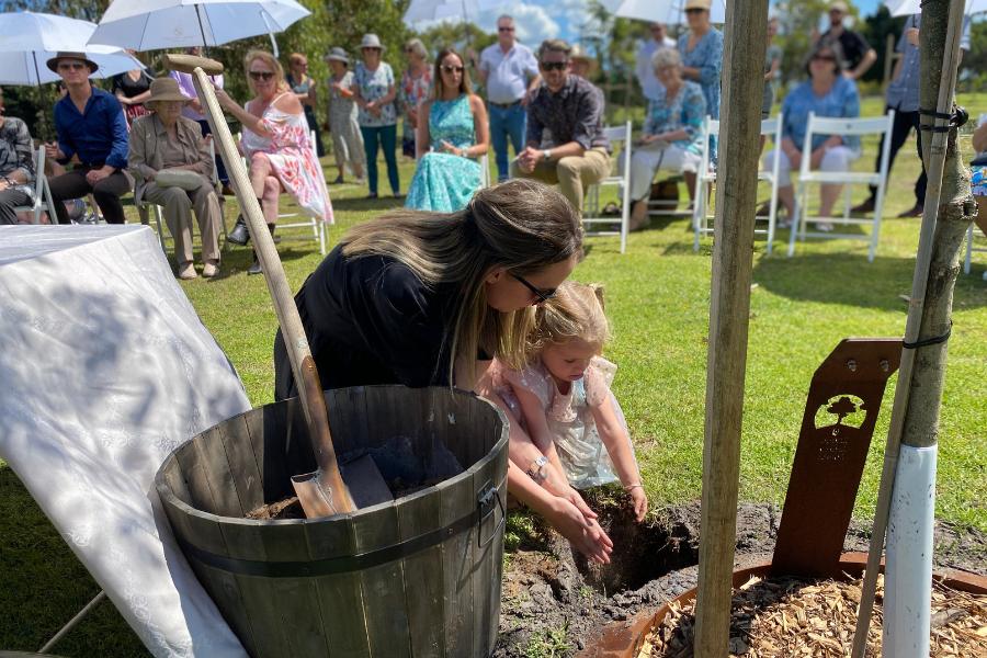 A woman and her daughter planting a Living Legacy Tree as an available alternative to human composting in Australia