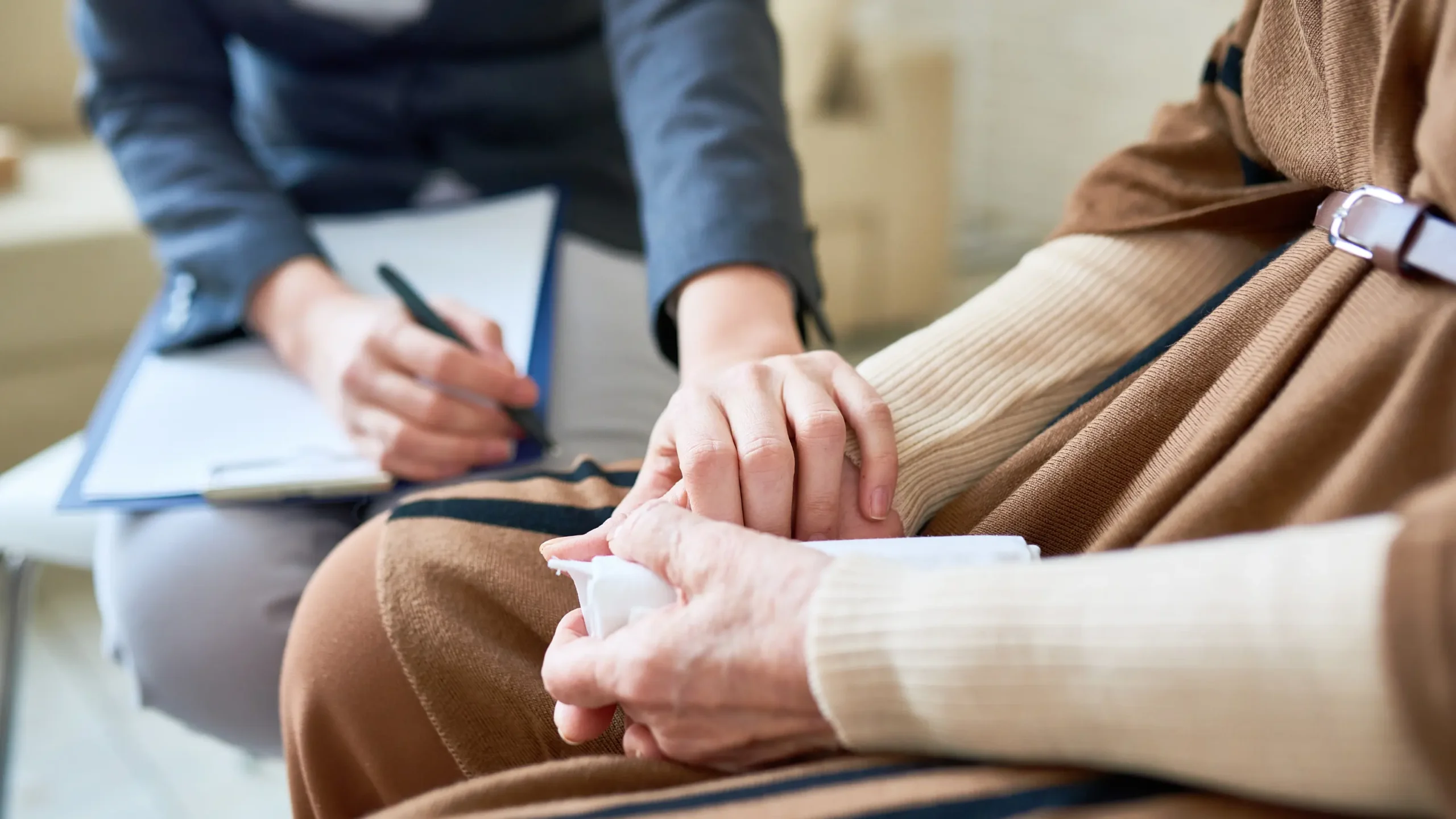 Support person holding hands with someone grieving to keep parent's memory alive.